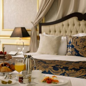 Elegant hotel room featuring a sumptuous breakfast spread with warm lighting decor.