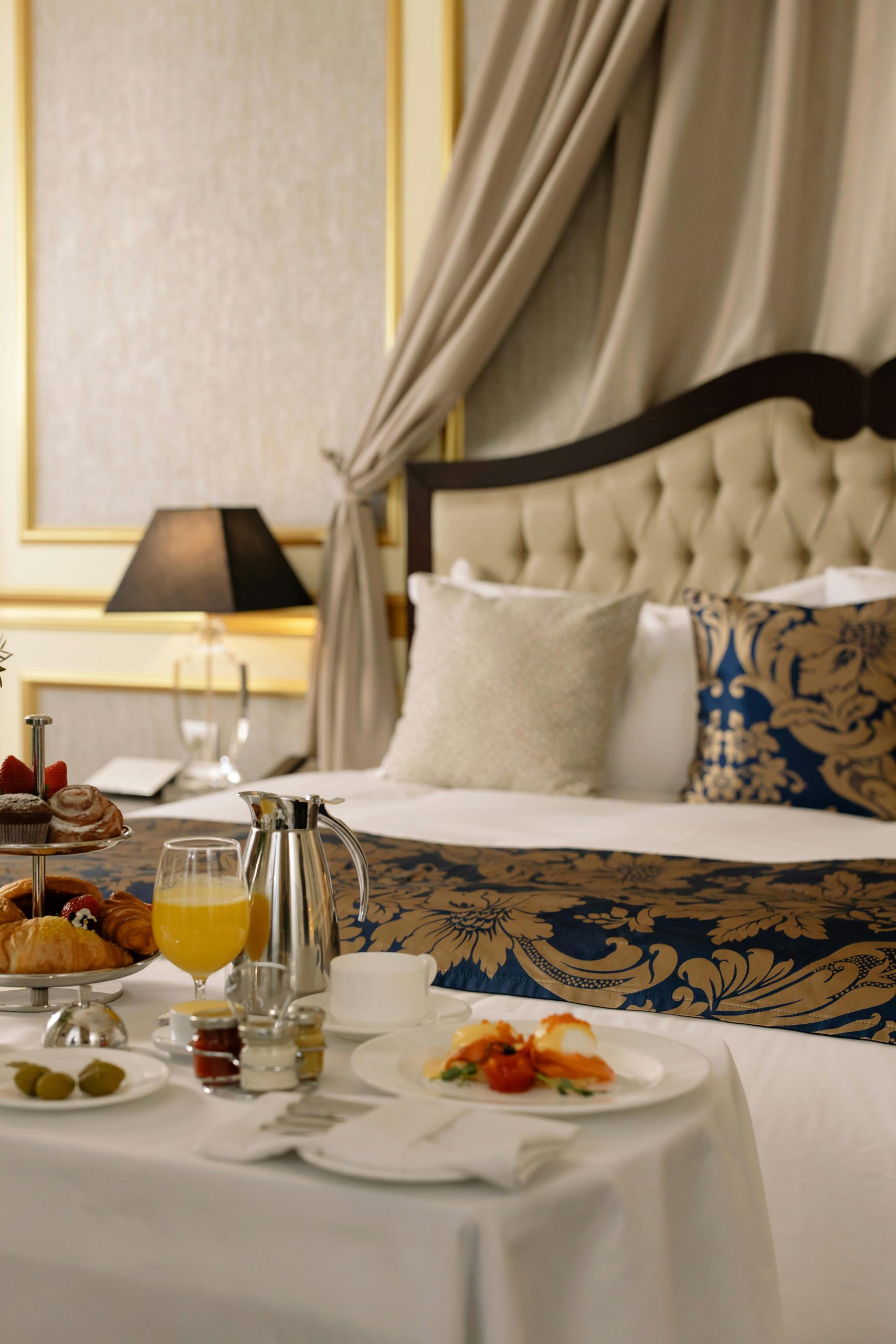 pexels photo 6466290 6466290 Elegant hotel room featuring a sumptuous breakfast spread with warm lighting decor.