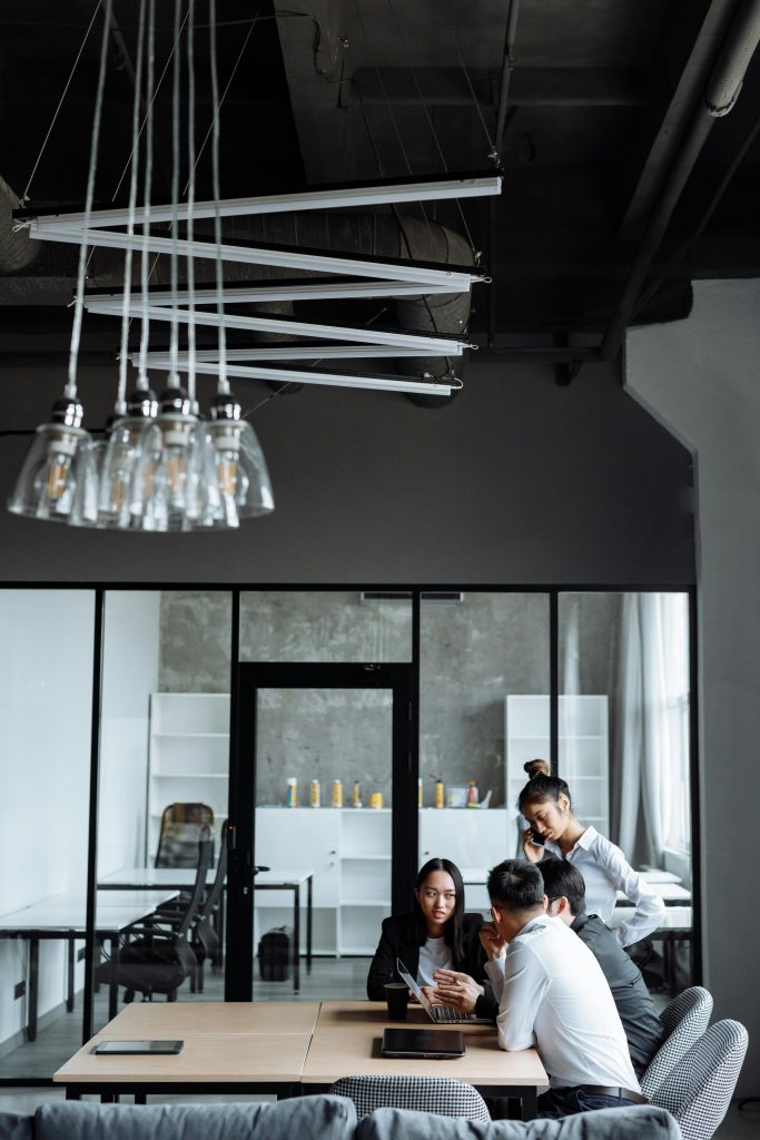 Business professionals engaged in a collaborative meeting in a stylish, modern office setting.